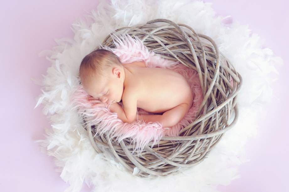 a baby sleeping on a twig basket